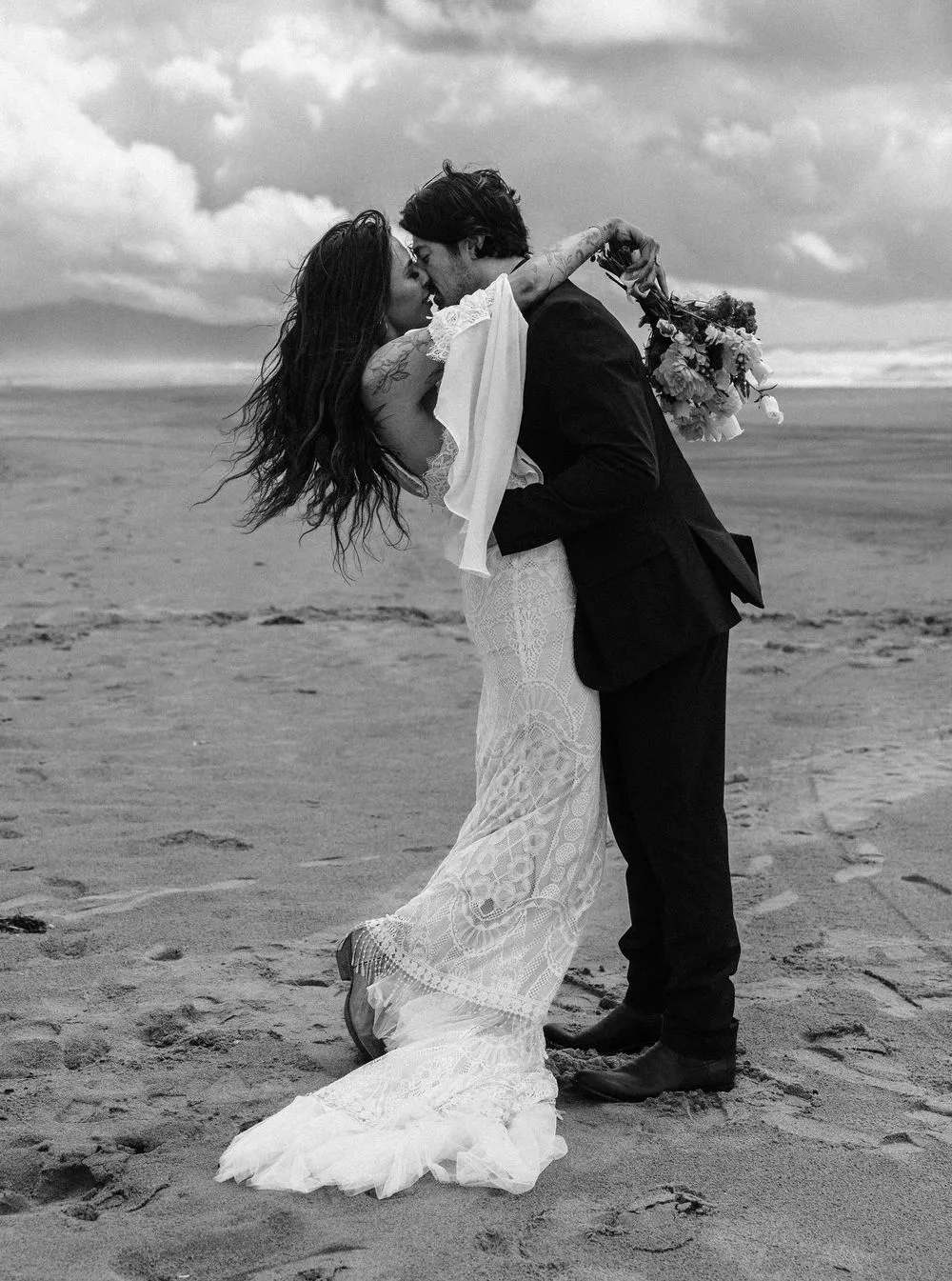 A couple embracing on the beach in black and white