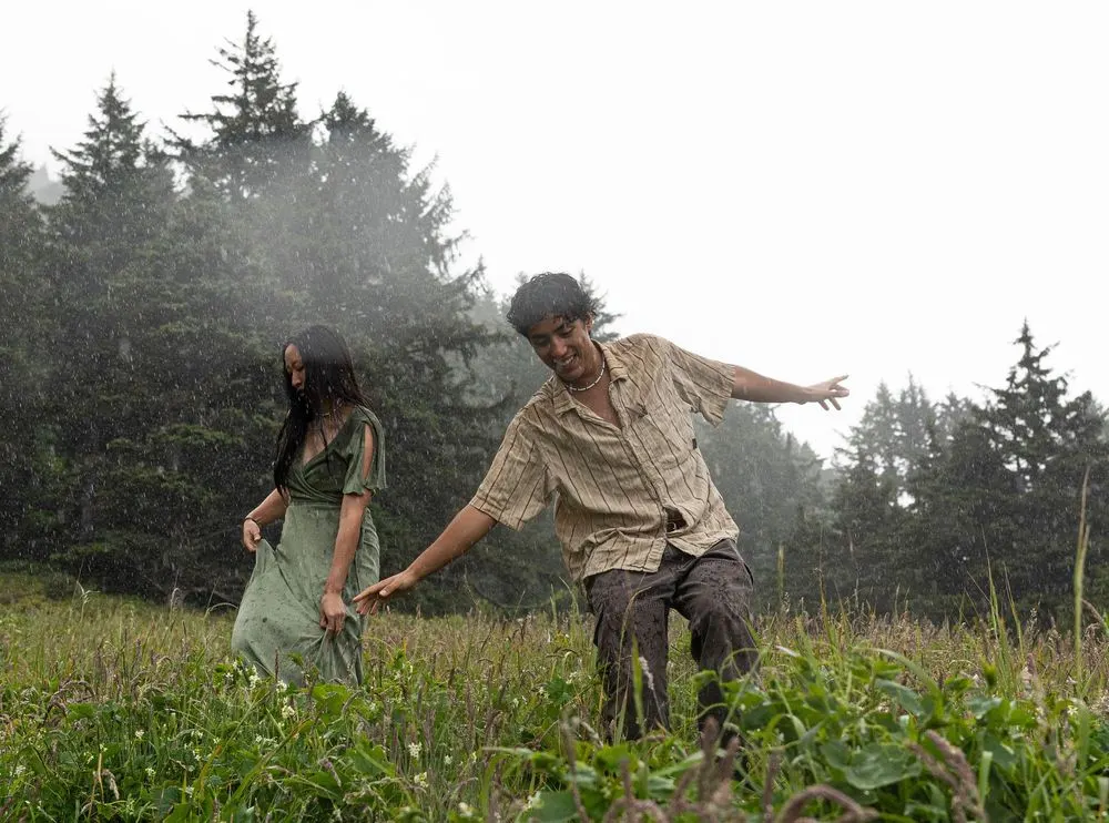 A couple reaching for one another in a misty field